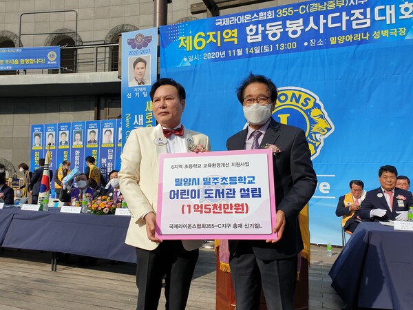 국제 라이언스 경남중부지구 신기일 총재가 도서기금을 전달하고 있다.(사진제공=밀주초등학교)